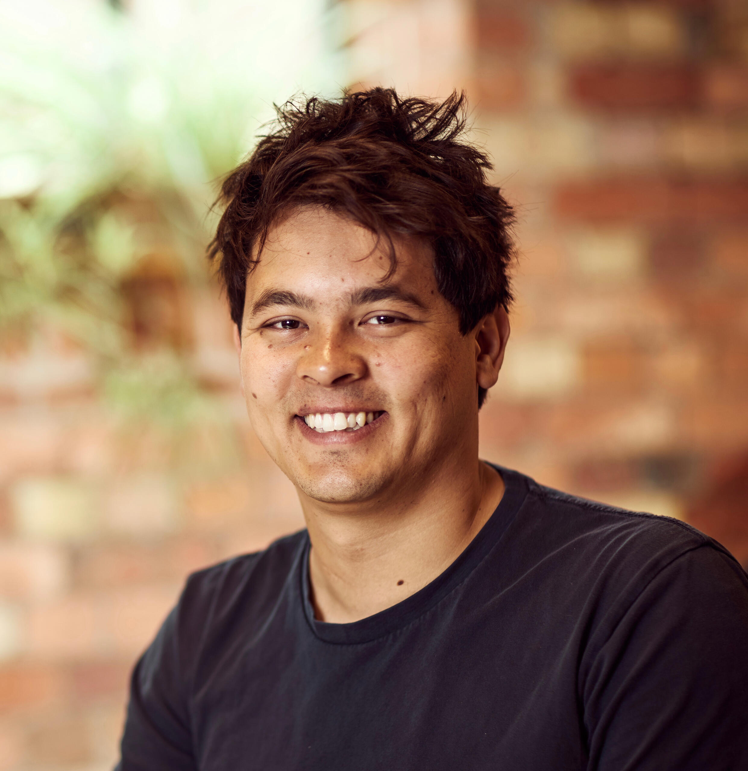 Headshot of Matt. Matt is a mixed-race 30-something year old male with short black hair, brown eyes and wearing a blue t-shirt whilst smiling at the camera